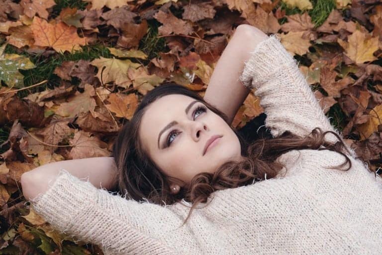 woman laying in leaf pile